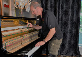 Ira working on a piano - Piano Restoration / Repair
